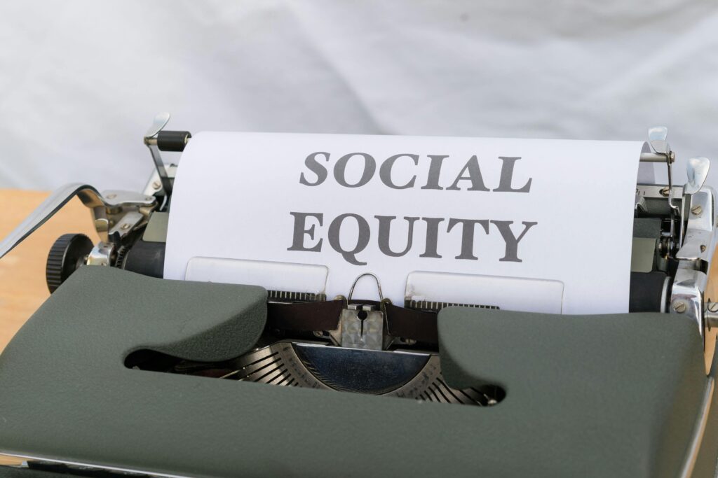 Close-up of a vintage typewriter displaying the message 'Social Equity' on paper.